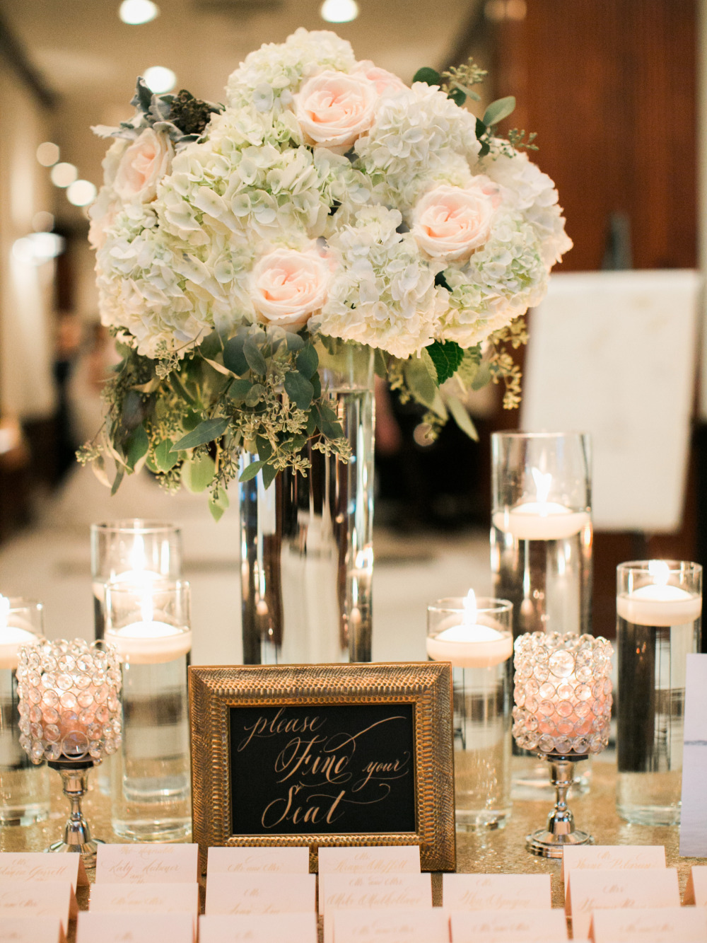 candle and floral decorated escort card table