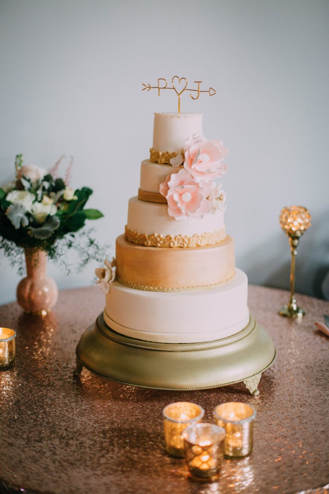 gold and white wedding cake with pink sugar flowers