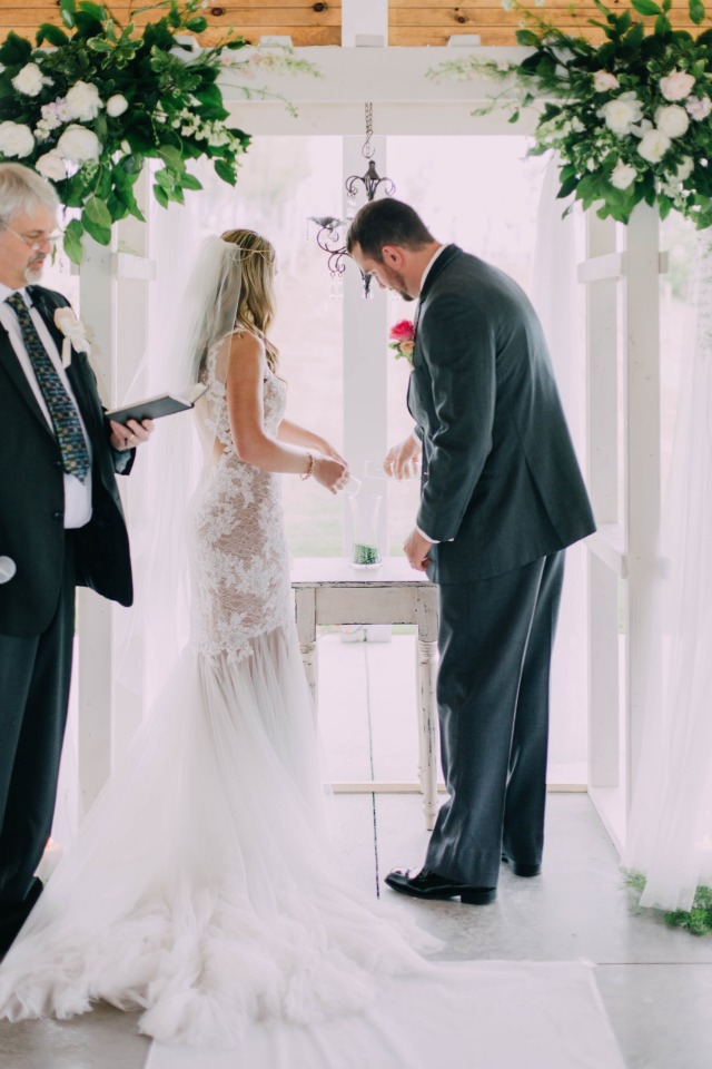 bride and groom pouring glass fragments together to create a vase.