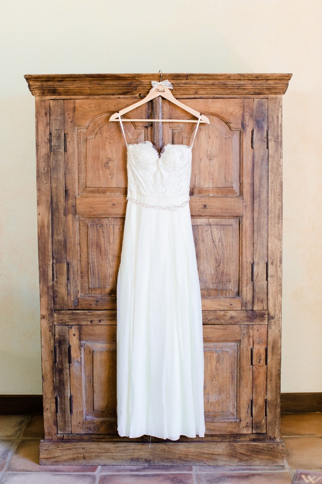 Ivory wedding dress on wood wardrobe ready for bride