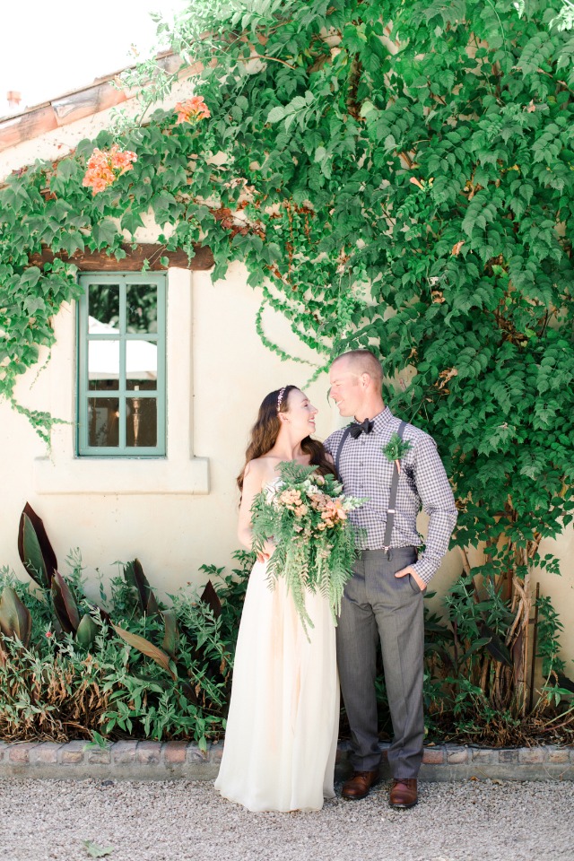 Bride and groom smile at their outdoor wedding venue