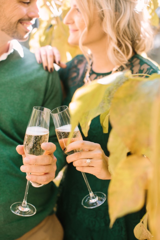 Happy couple cheers champagne glasses in celebration outdoors
