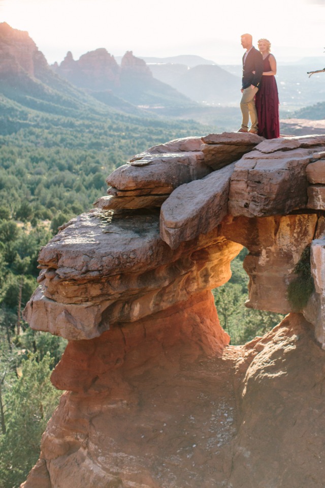 Couple on Sedona rock formation with scenic valley view