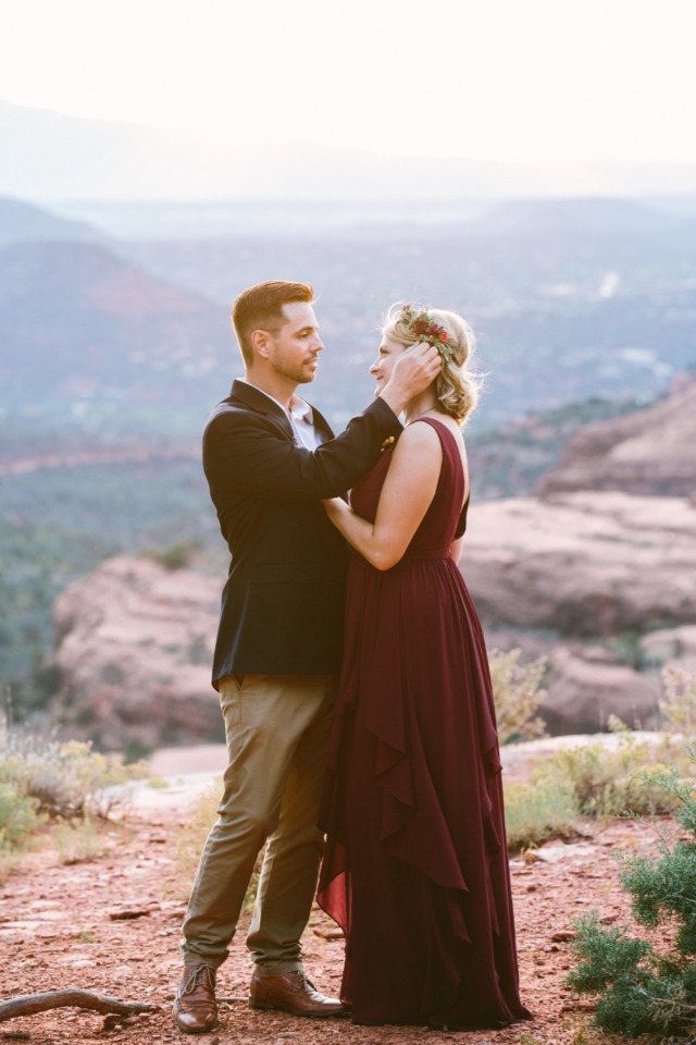 Couple in mountain, man tenderly adjusts womans hair