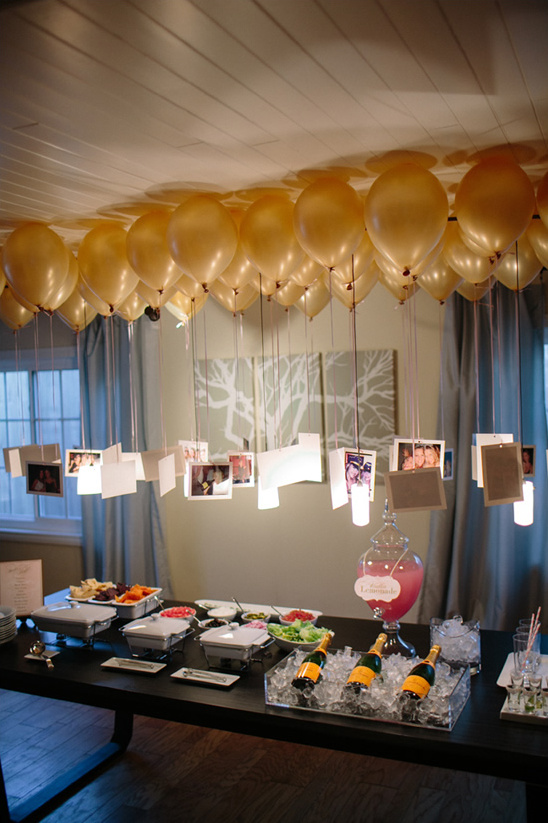 Festive party with gold balloons hanging photos food table