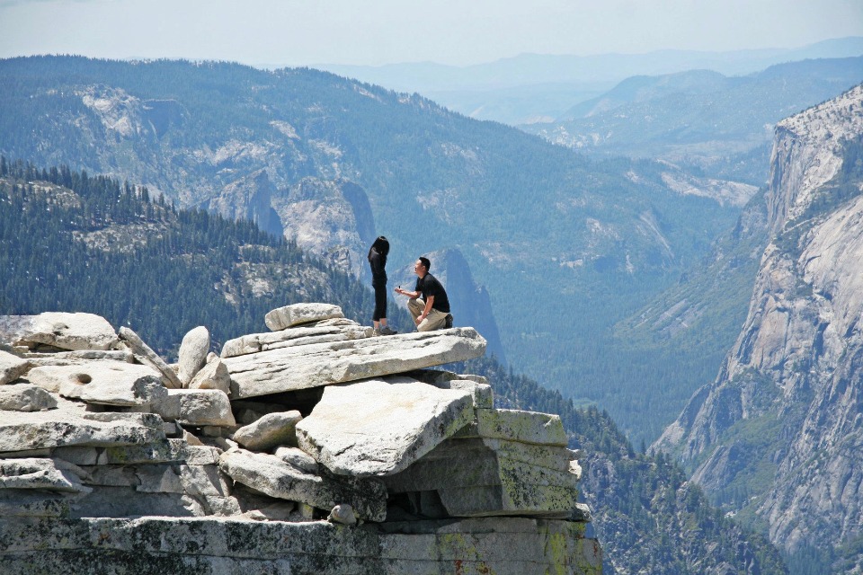 Man proposes atop mountain vista