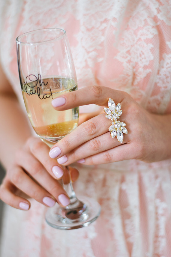 Woman holding champagne flute with Oh Lala text and sparkly ring