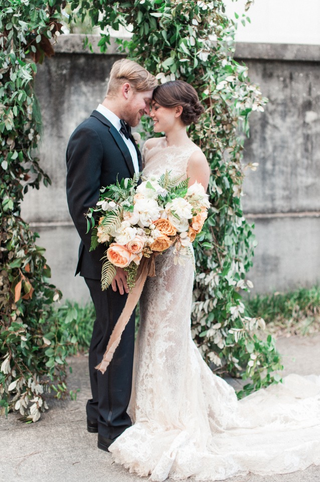 Elegant couple on wedding day, floral arch and dress