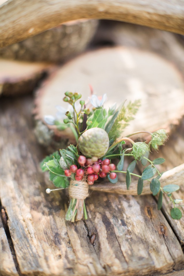 Rustic wedding boutonniere with berries and greenery