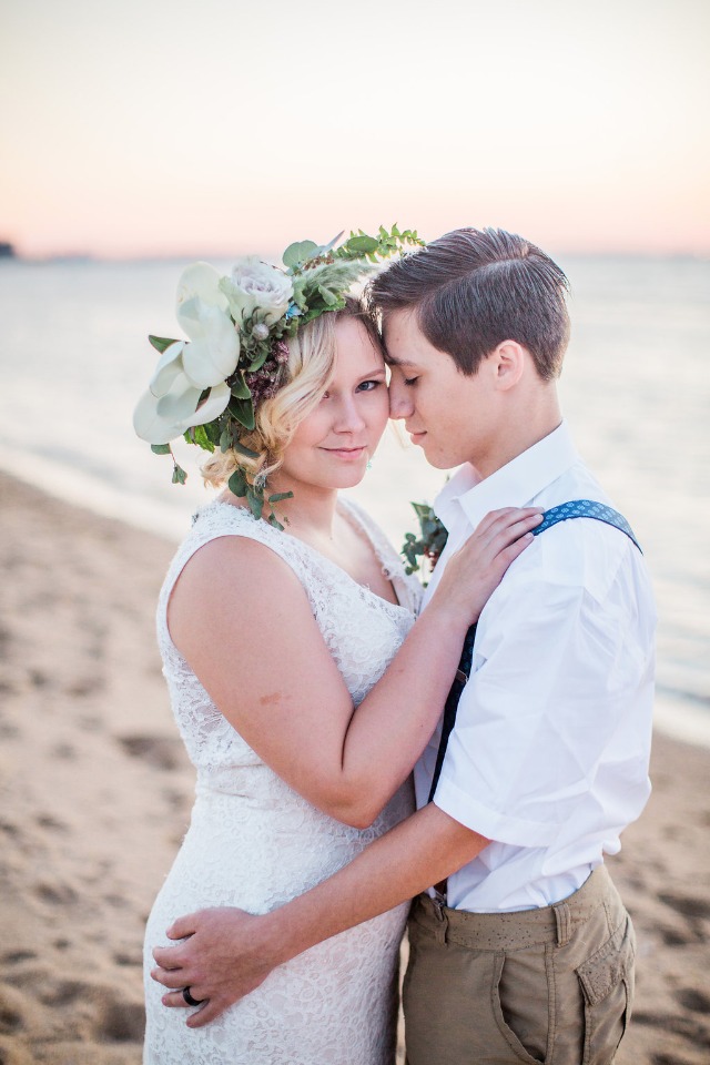 Romantic lesbian couple embracing on beach at sunset