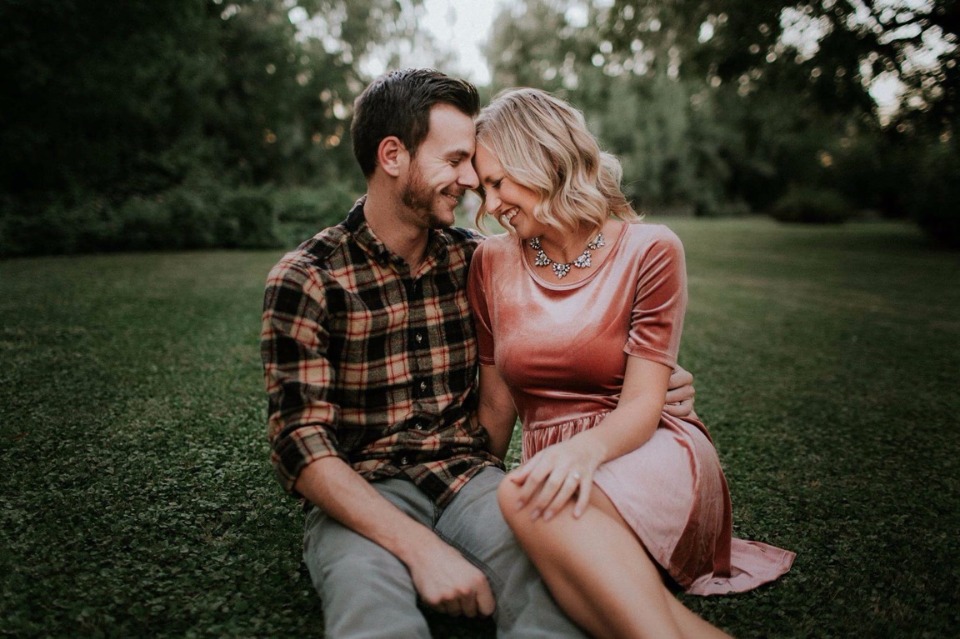 Happy couple embracing outdoors on grassy lawn