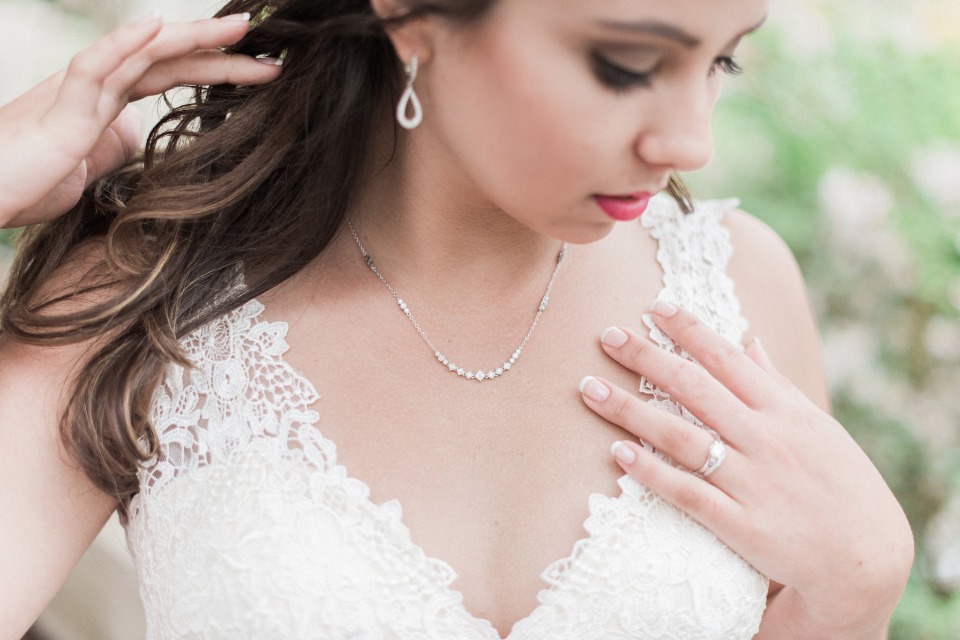 Elegant bride in lace wedding dress with delicate necklace