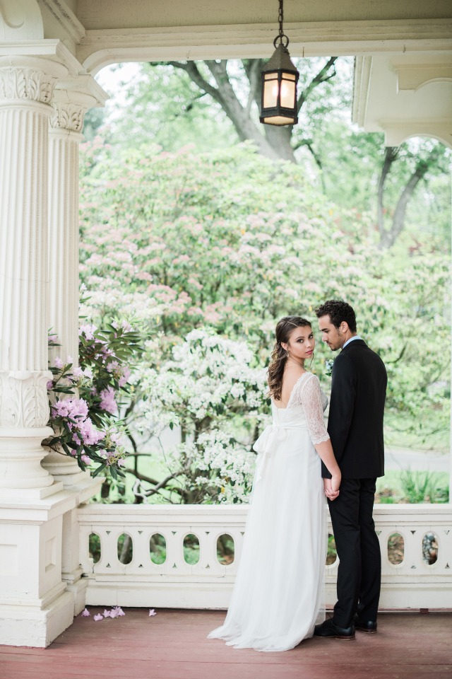 Bride and groom holding hands on a veranda wedding day
