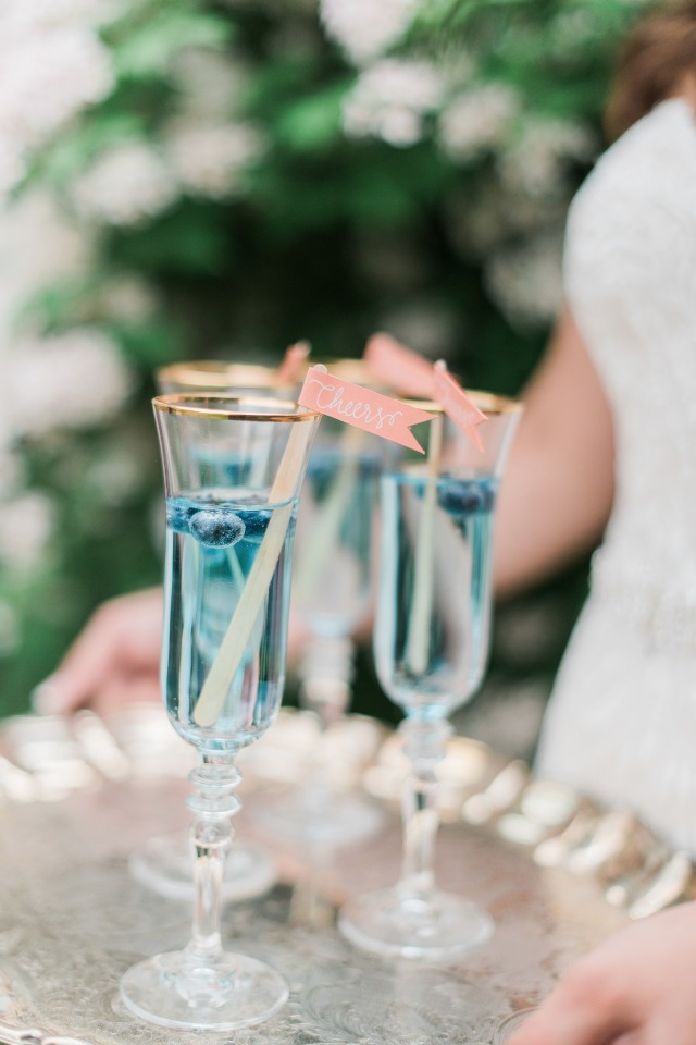Refreshing blue drinks with cheers flags on a tray
