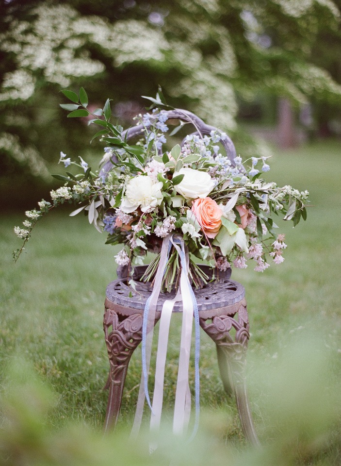 Elegant wedding bouquet with ribbons on a vintage chair