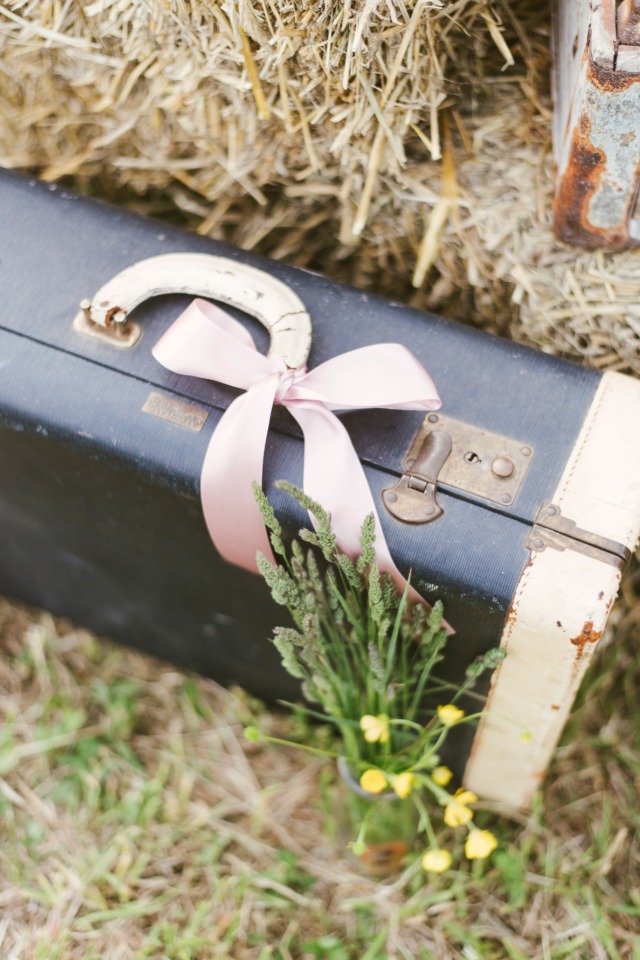 Vintage suitcase adorned with pink bow and wildflowers