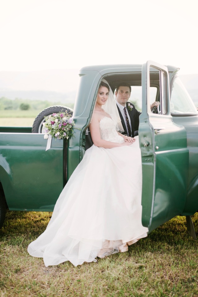 Beautiful bride and groom in a green vintage truck on their wedding day