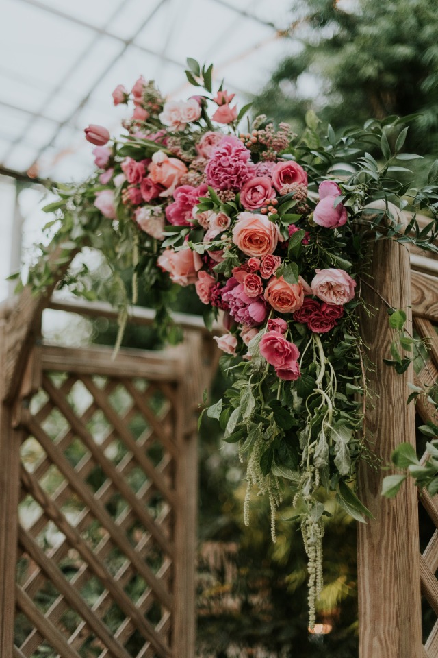pink and peach flower accented wedding arch