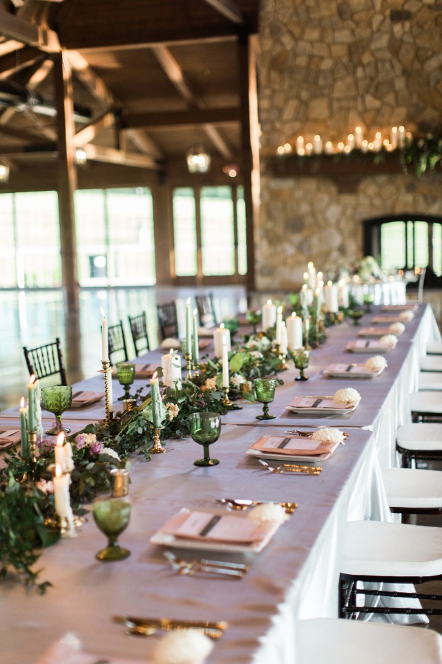 family style seating with garland and candles decorating the table