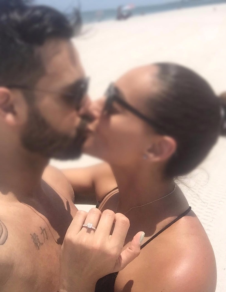 Romantic couple kiss beach showing ring