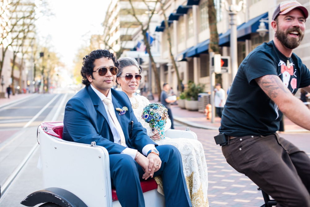 Newlyweds ride in a carriage driven through city streets