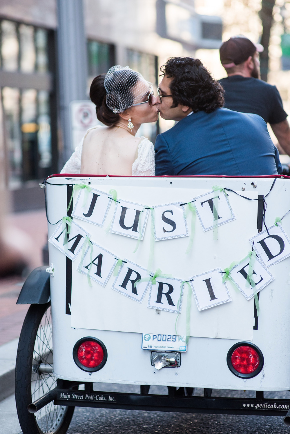 Just married couple kiss in pedicab on wedding day