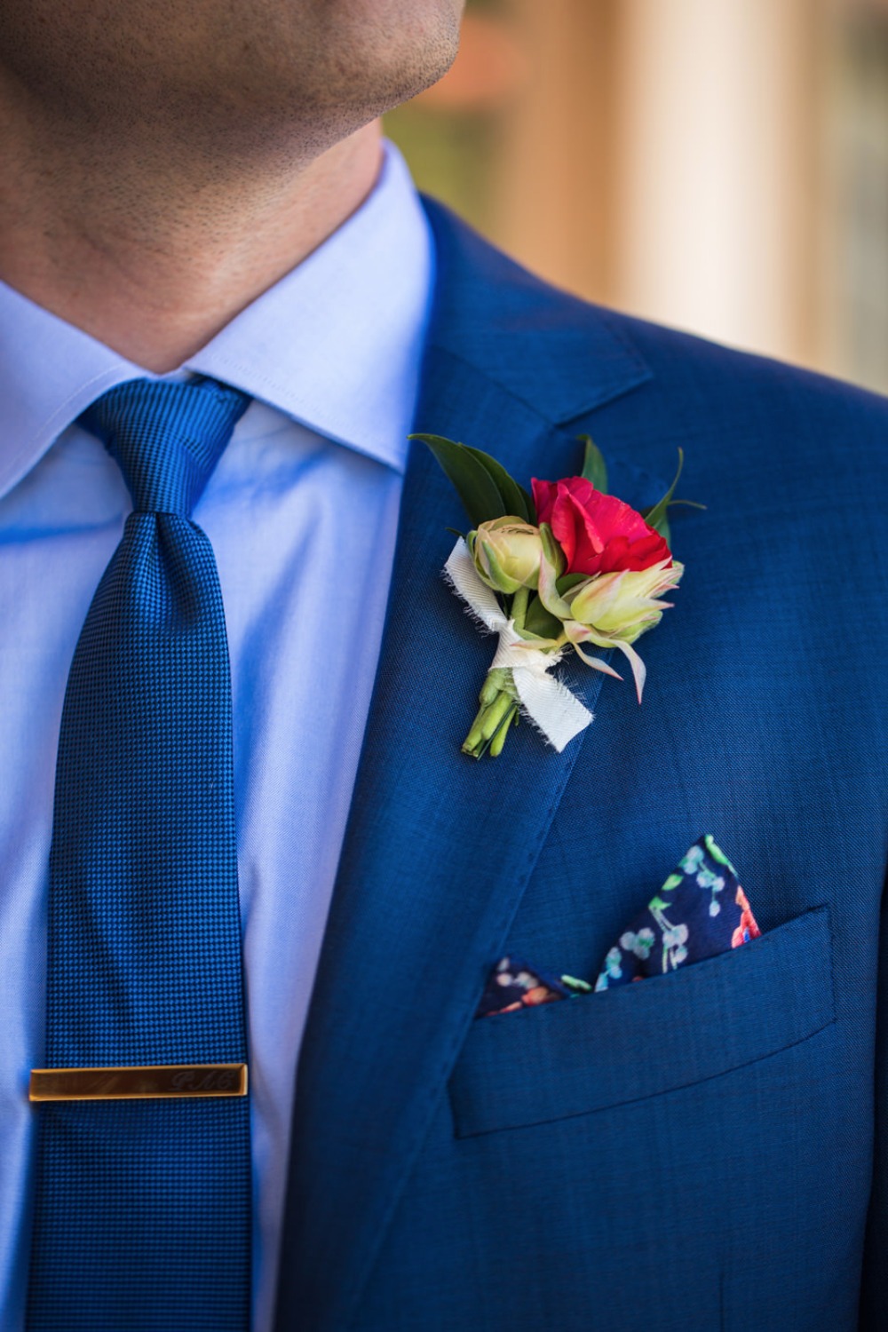 Blue suite with a pink flower boutonniere