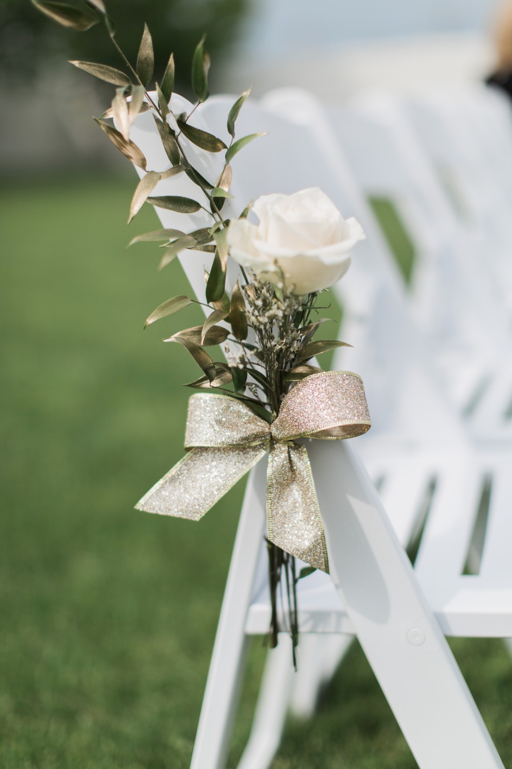 Wedding chair decorated with rose and golden ribbon