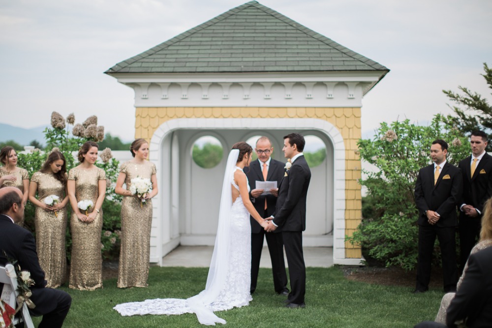 Outdoor wedding ceremony with bridesmaids in gold gowns