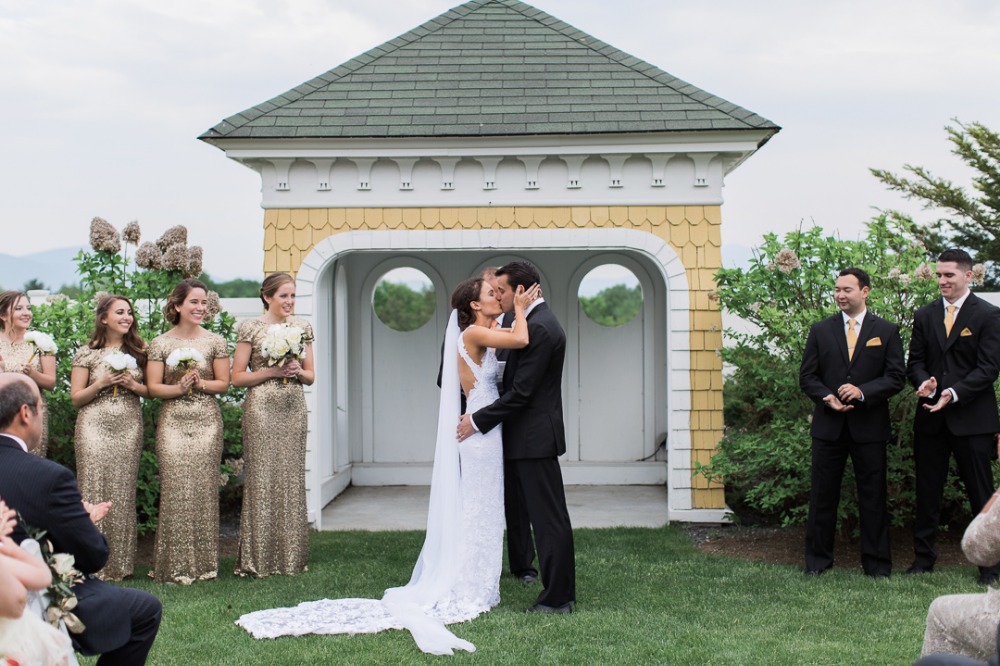 Bride and groom share kiss at outdoor wedding gazebo