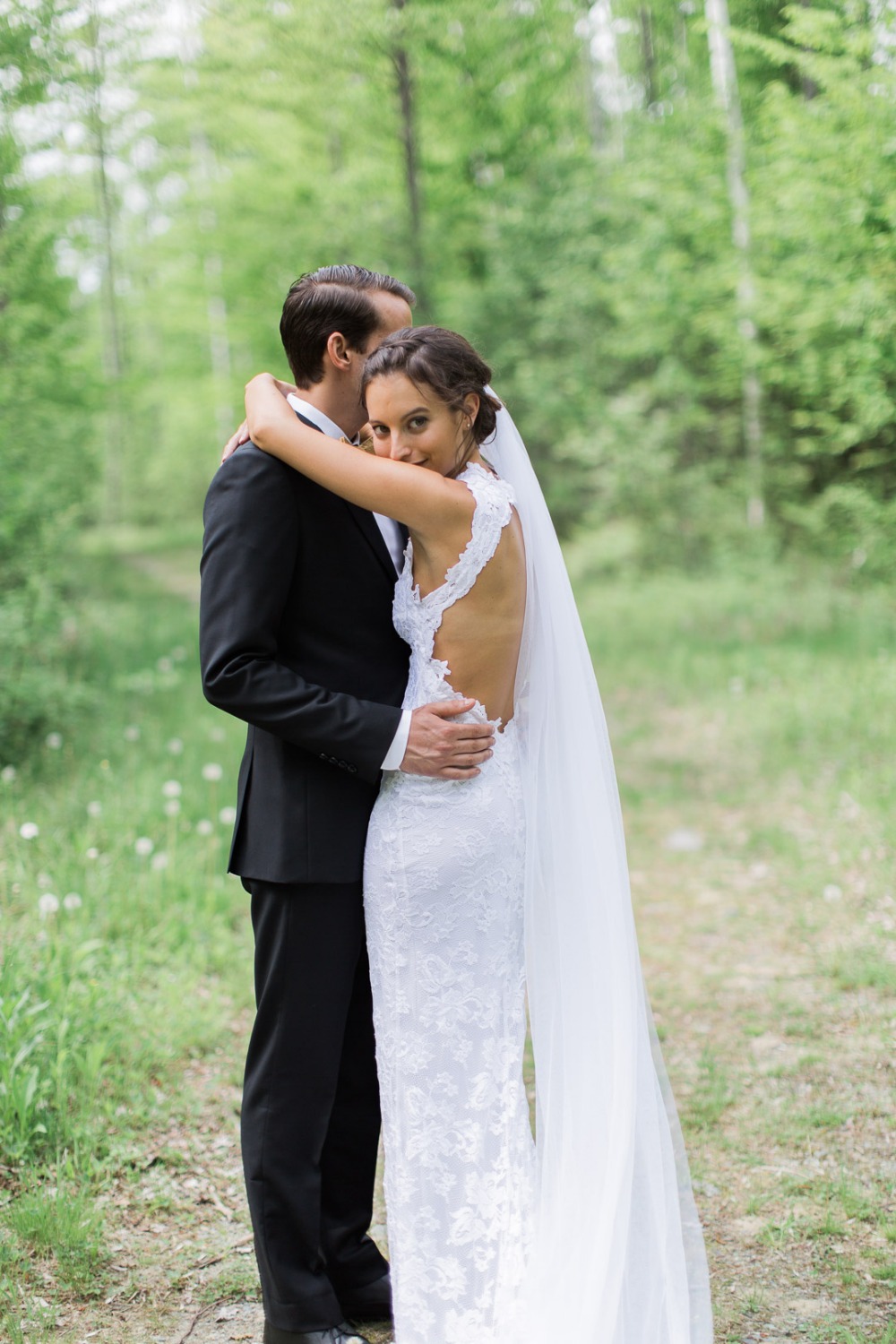 Bride embraces groom in romantic outdoor wedding scene
