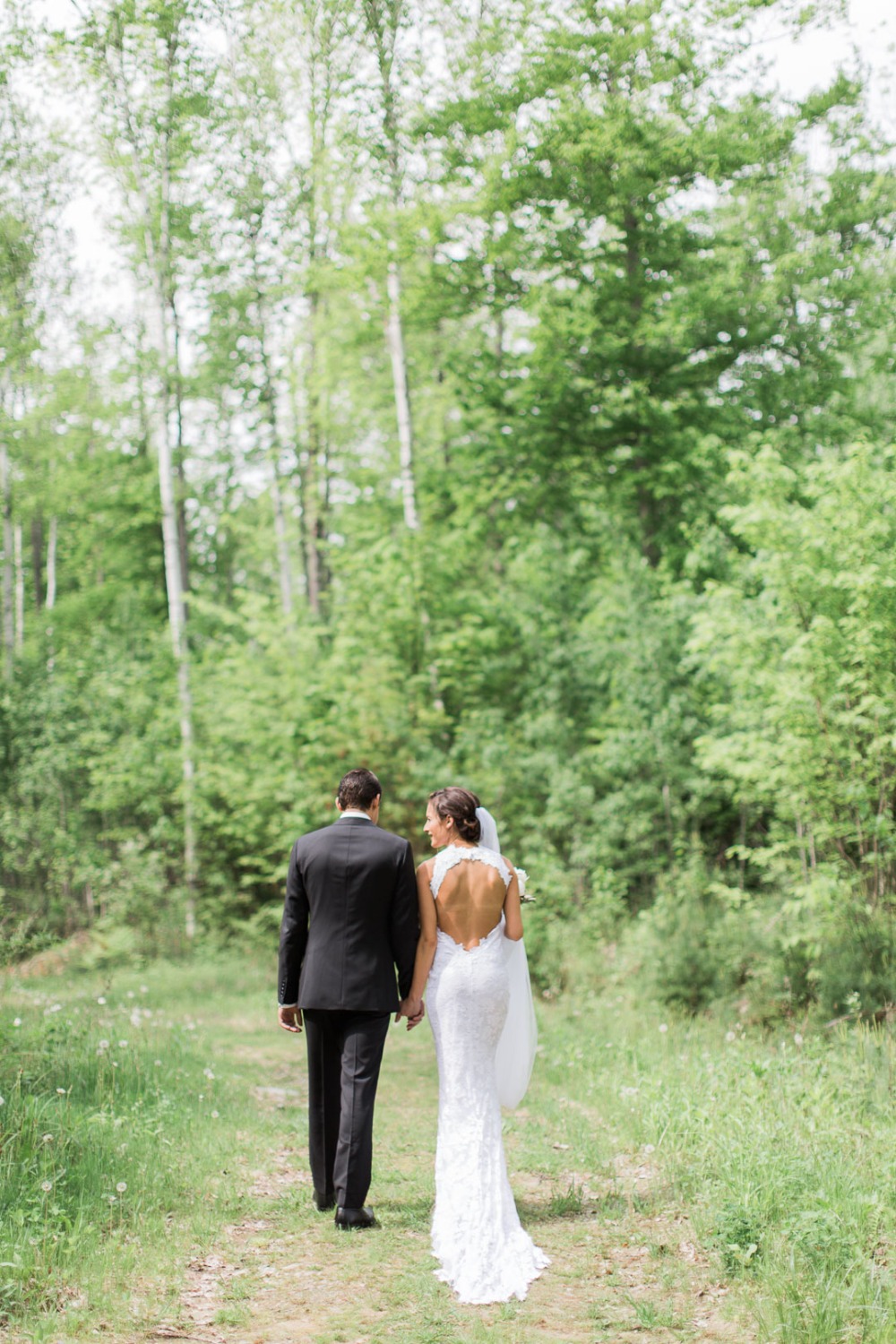 Bride and groom walk in woods on their wedding day