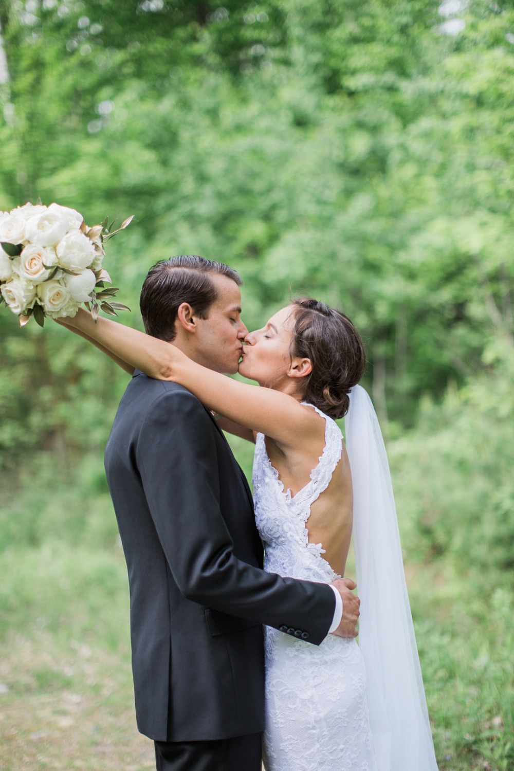 Bride and groom share a kiss after their outdoor wedding