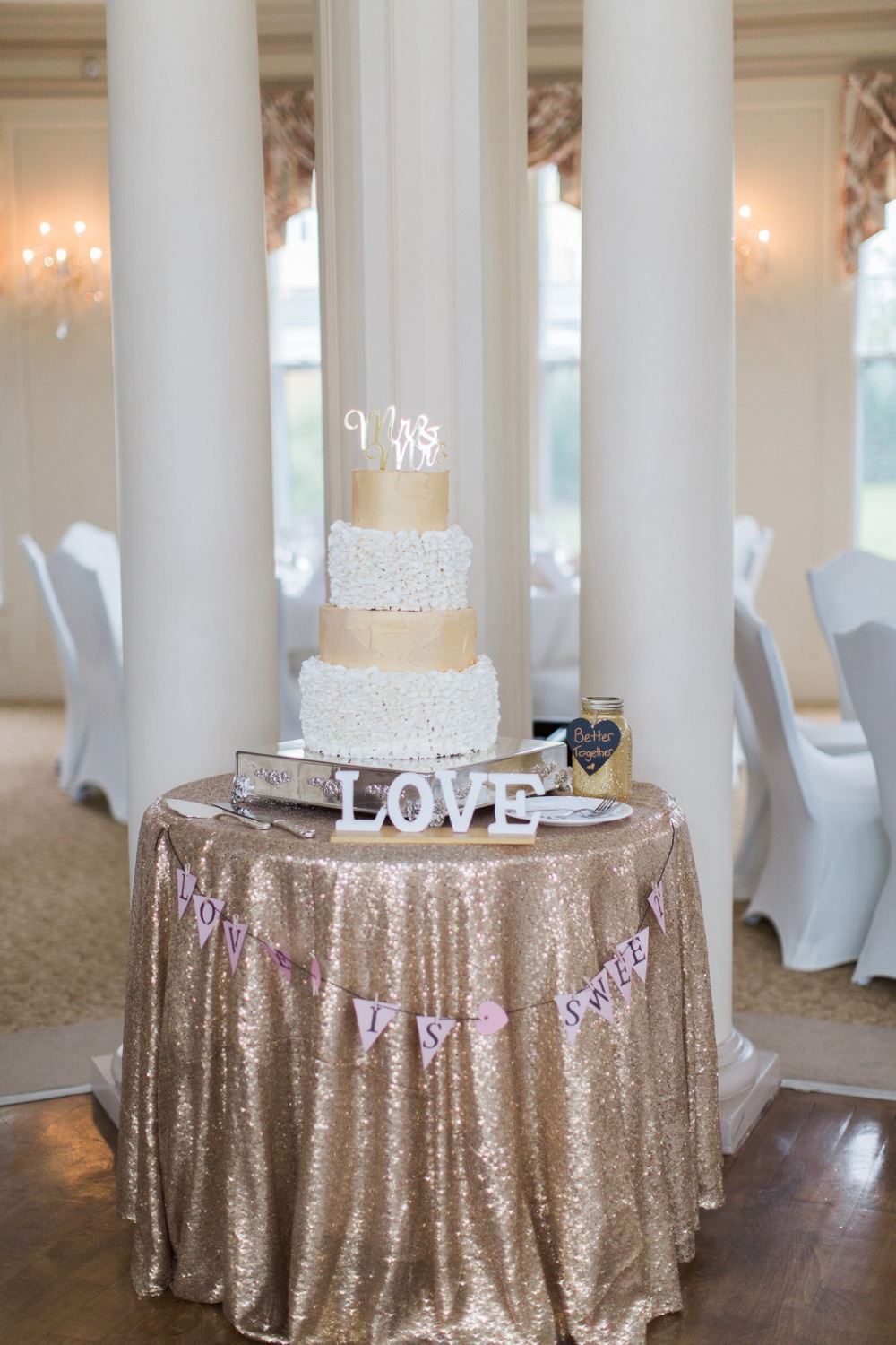 Elegant wedding cake on a sequined table with Love sign
