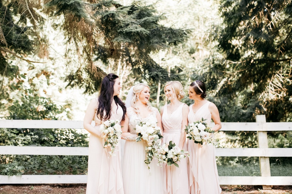 Happy bride with bridesmaids in blush pink dresses