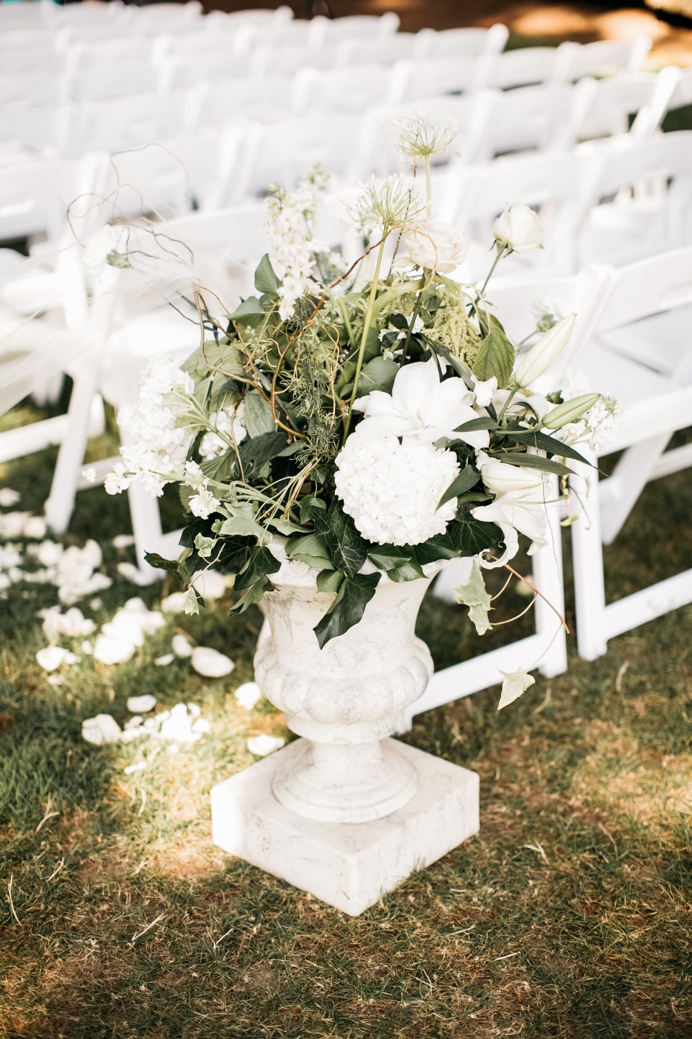 Outdoor wedding aisle with flowers in a stone vase