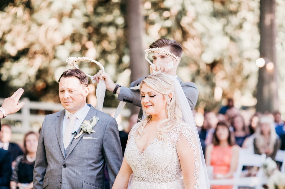 Wedding ceremony: Bride and groom crowned with floral wreaths