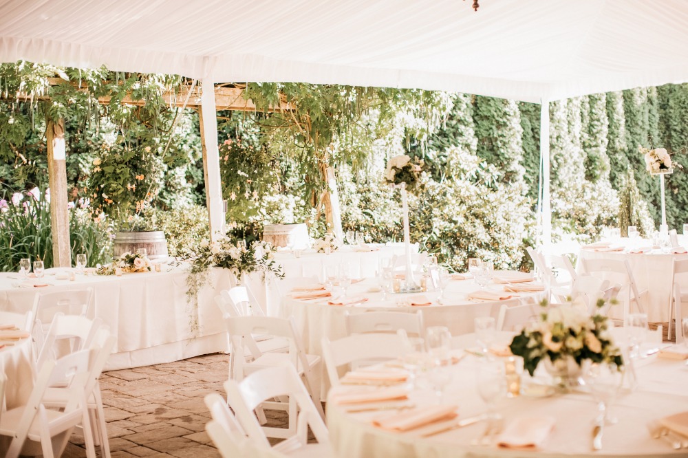 Outdoor wedding reception with tent and garden decor