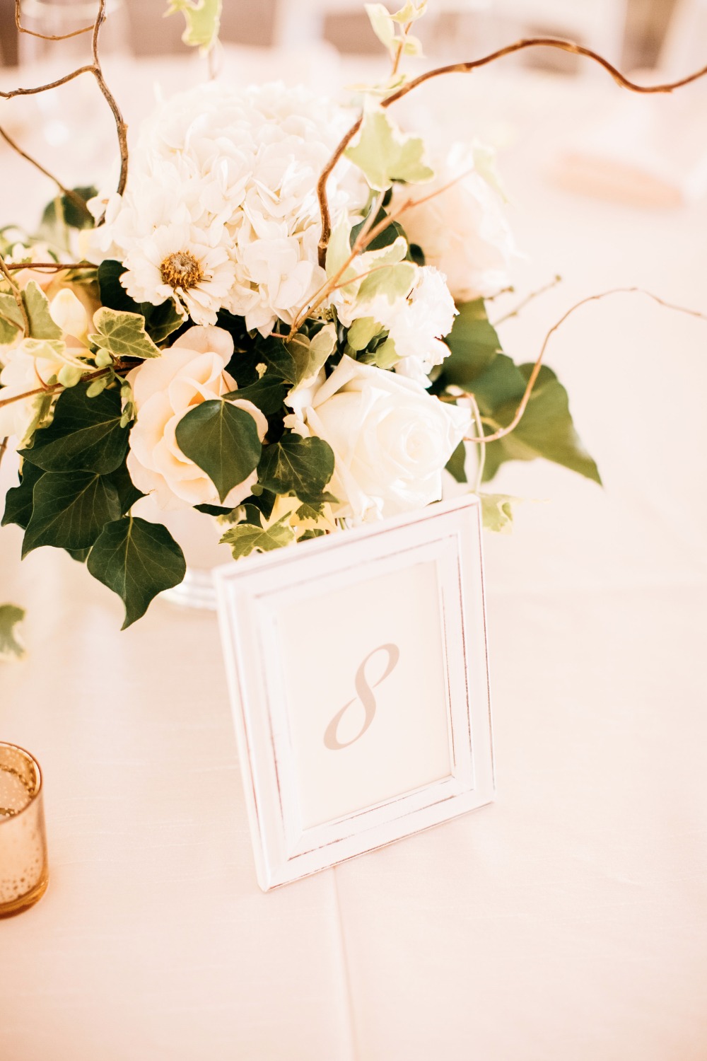 Wedding table decor with floral arrangement and table number