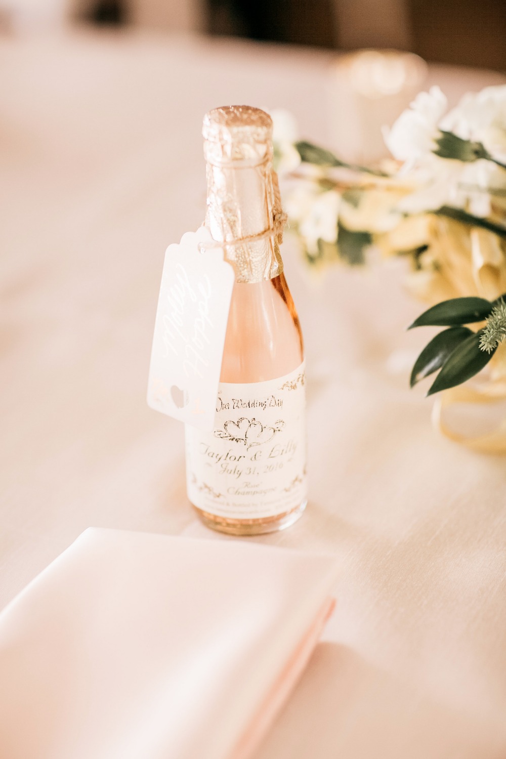 Wedding favor of miniature rose wine bottle and tag