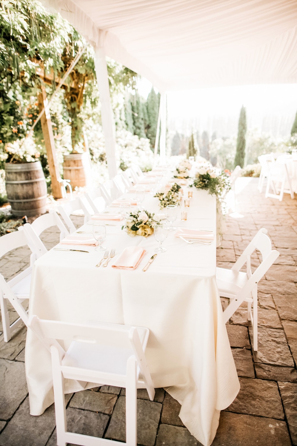 Elegant outdoor wedding reception with long white tables