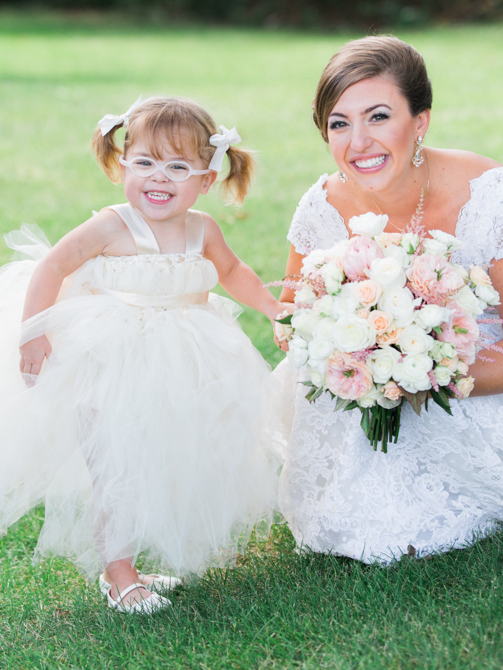 Bride with flower girl in a pretty white dress smiling