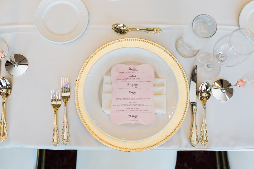 Elegant wedding table setting with gold accents and menu