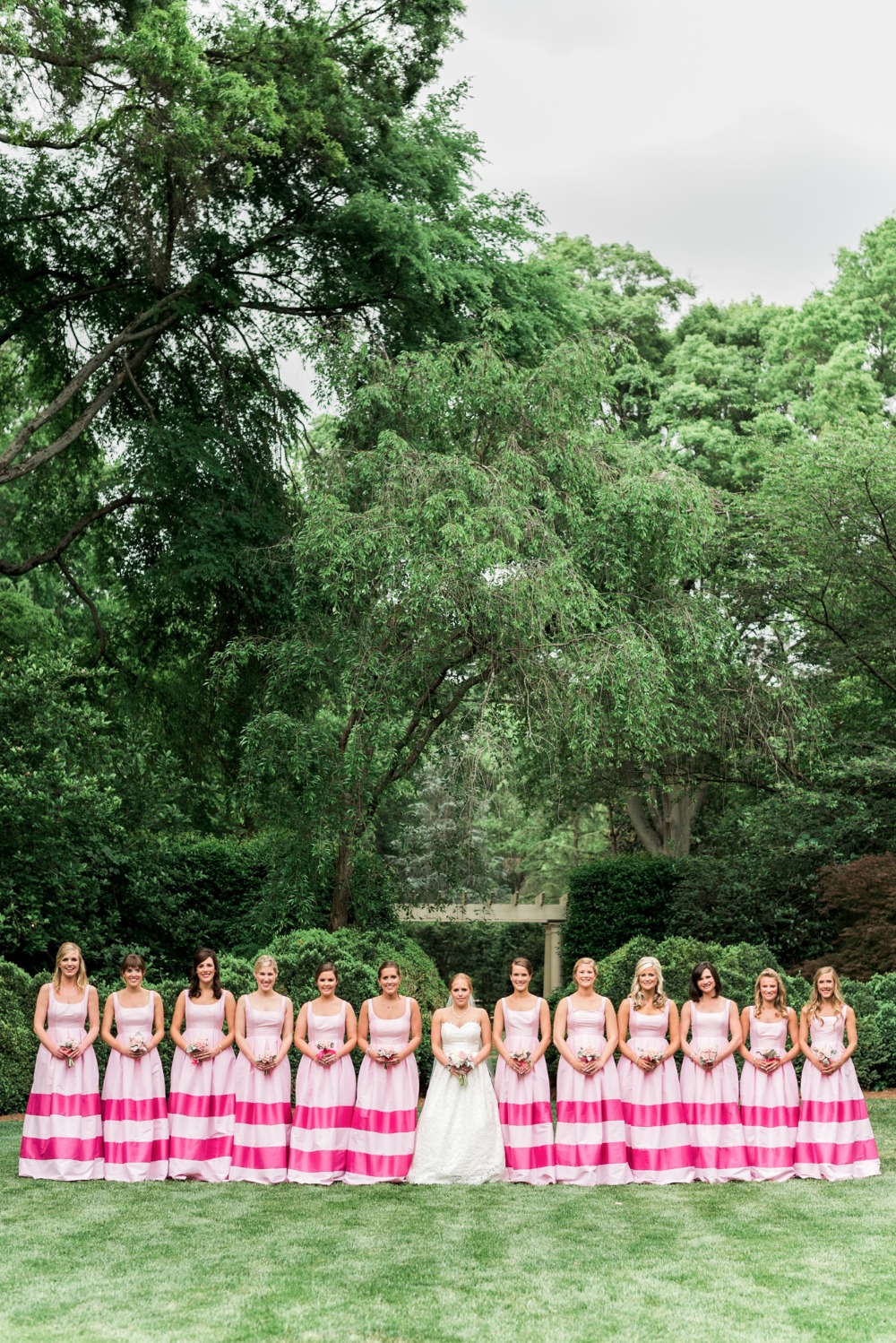 Bridesmaids in matching pink striped gowns