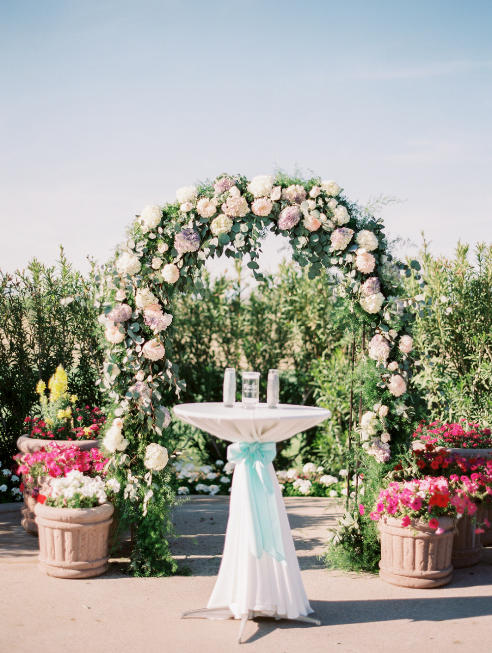 wedding ceremony with big pink flower arch