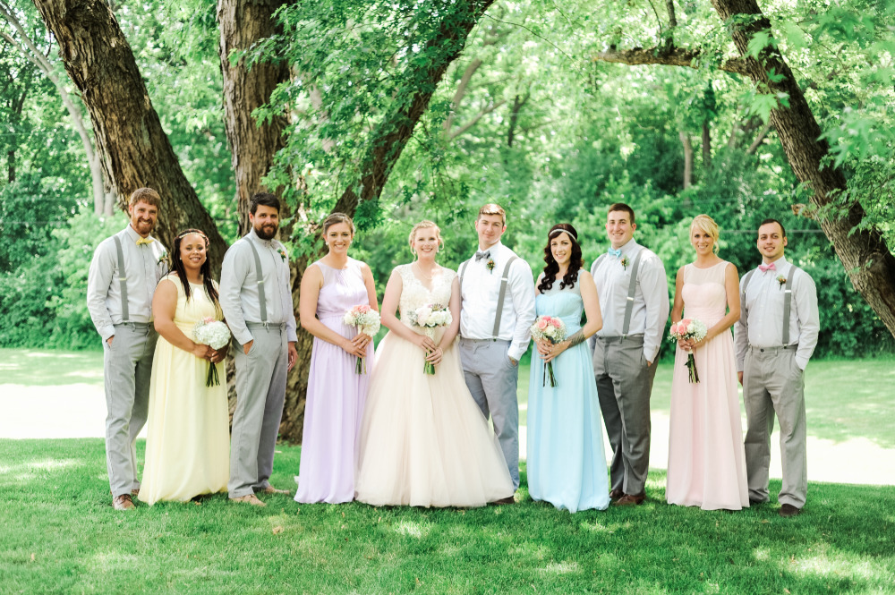 Bride and wedding party in pastel dresses outdoors