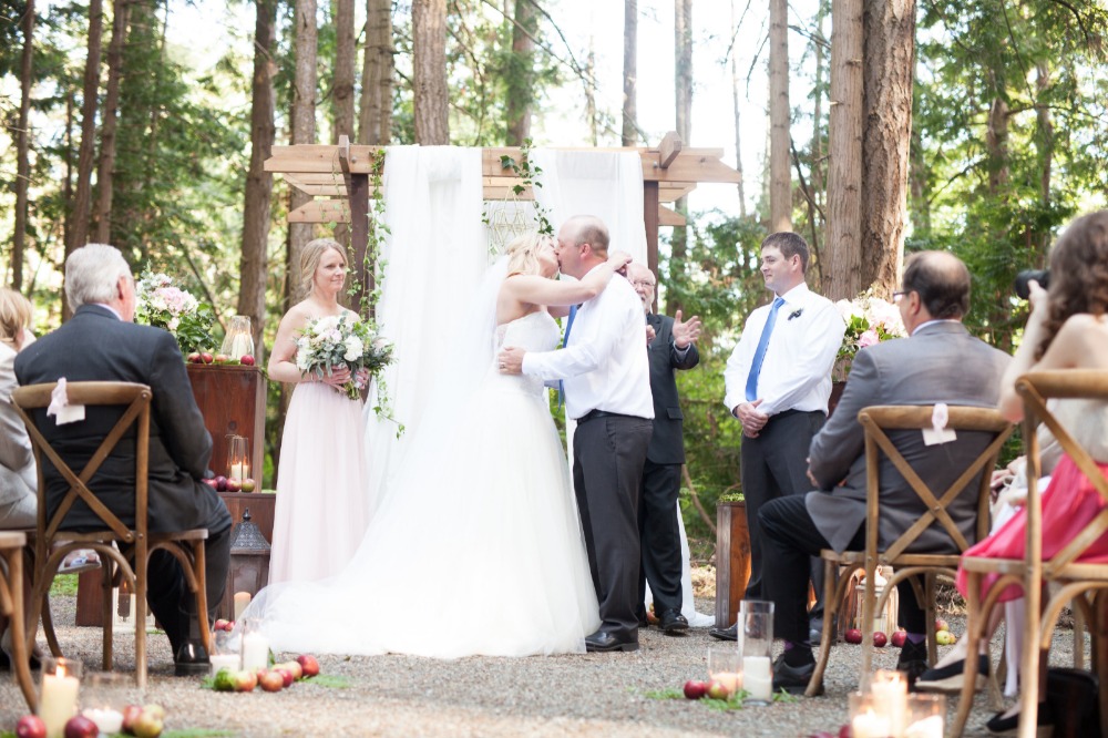 Bride and groom kissing at outdoor wedding ceremony