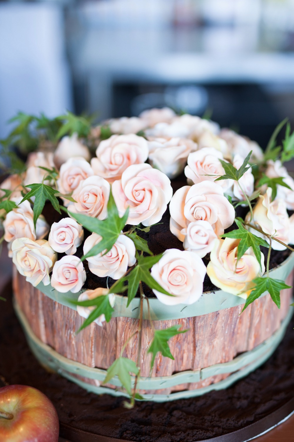 Rustic wedding cake with roses and green vines decor