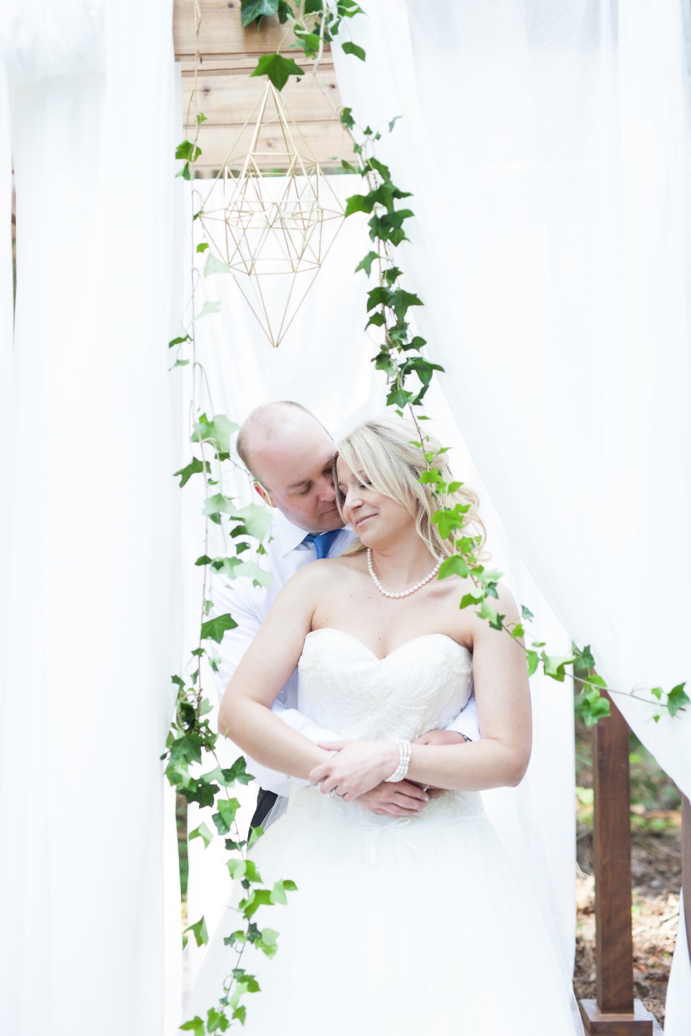 Happy couple embracing at romantic outdoor wedding ceremony