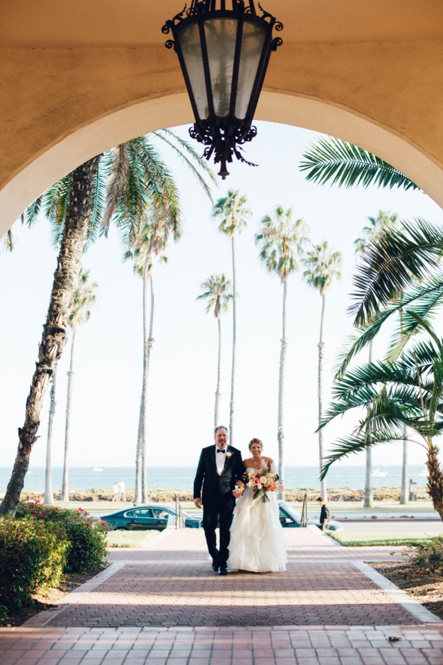Bride and father walking down the aisle on sunny wedding day